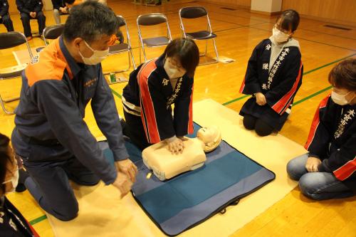 南消防署員から胸骨圧迫について指導を受ける女性消防協力隊員